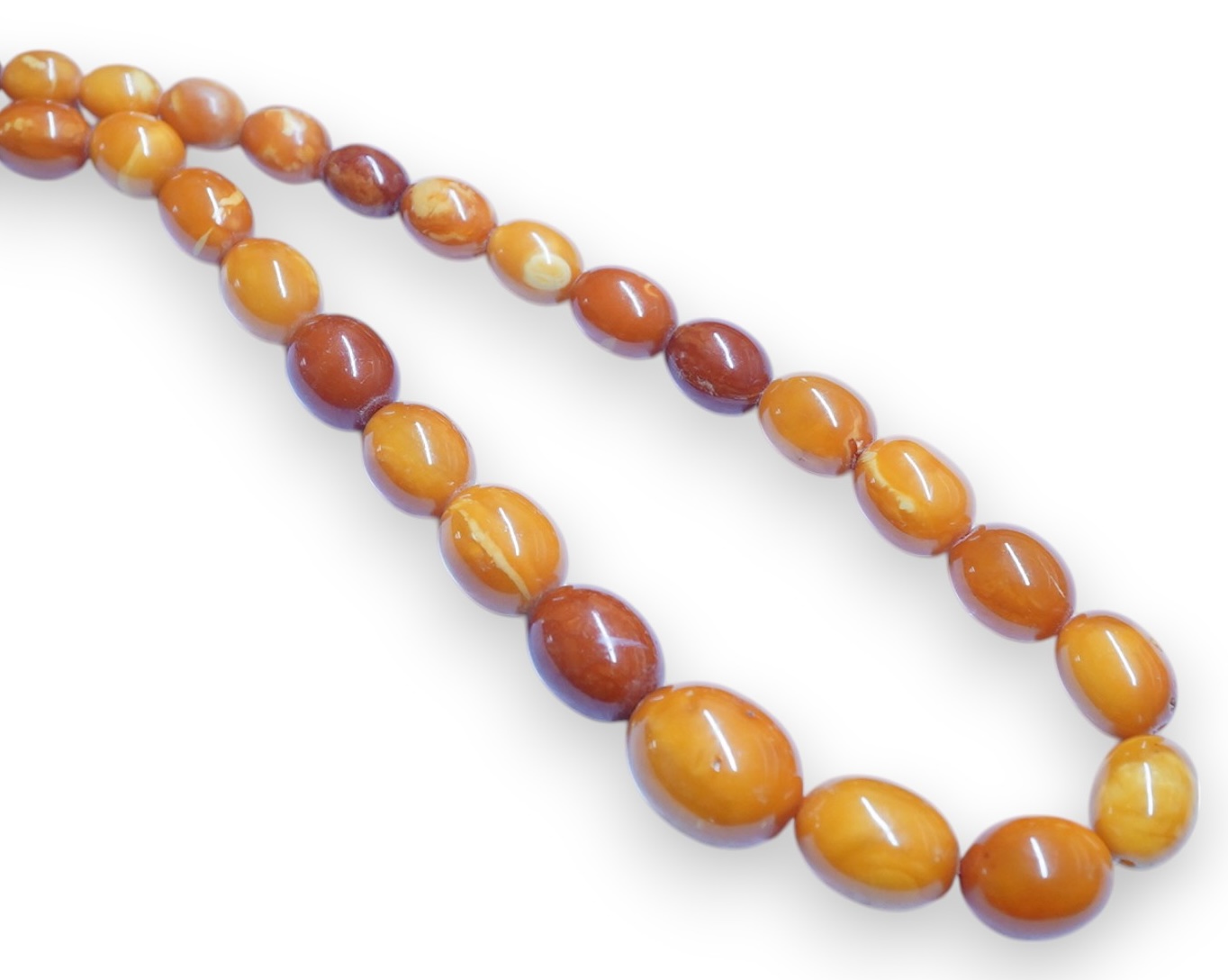 A single strand graduated oval amber bead necklace, 110cm, gross weight 103 grams. Condition - poor to fair